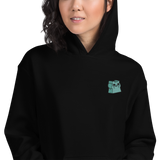 A model wearing a black hoodie with the Riverfolk Company otter meeple embroidered on the left chest.